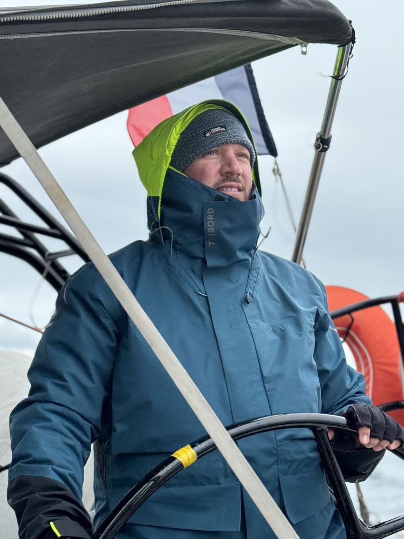 Michael Renfer at the wheel of a sailboat, looking ahead